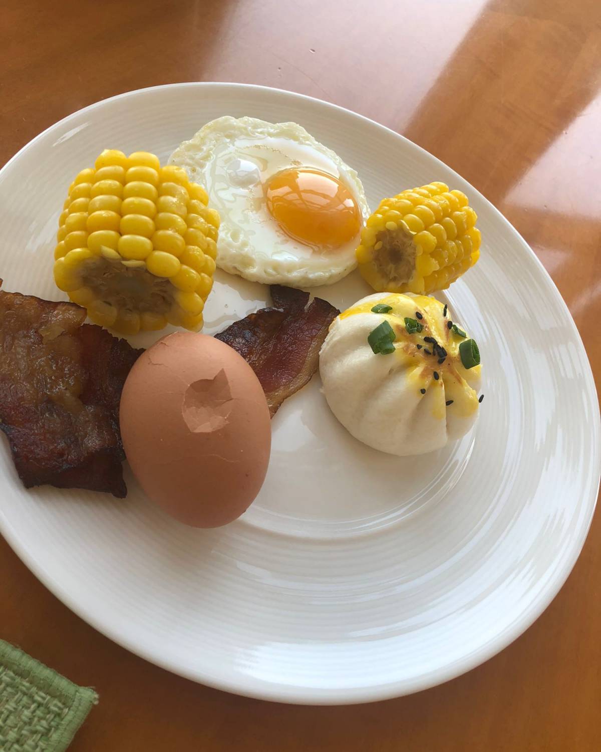 rt 一个单面蛋一个生煎包，两块玉米，两小片培根，一个水煮蛋