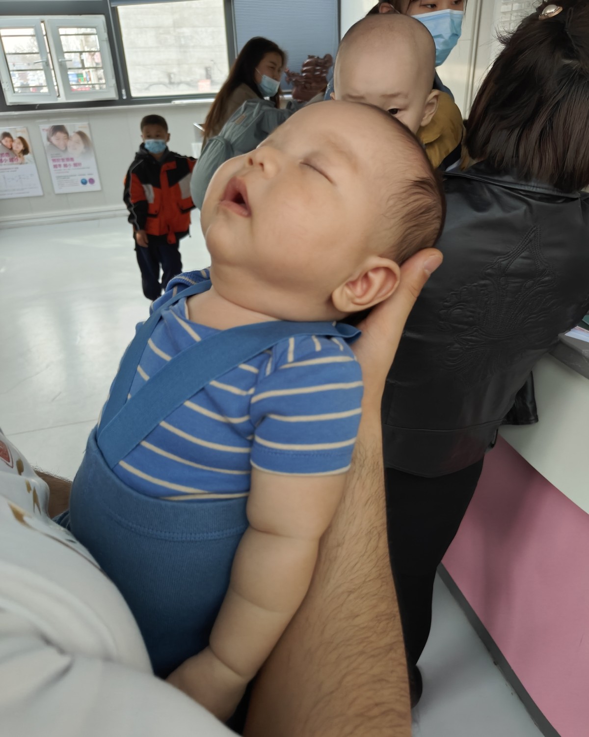 带宝宝去打满月疫苗，上身穿的是蓝色条纹包*衣，下身穿的是0-