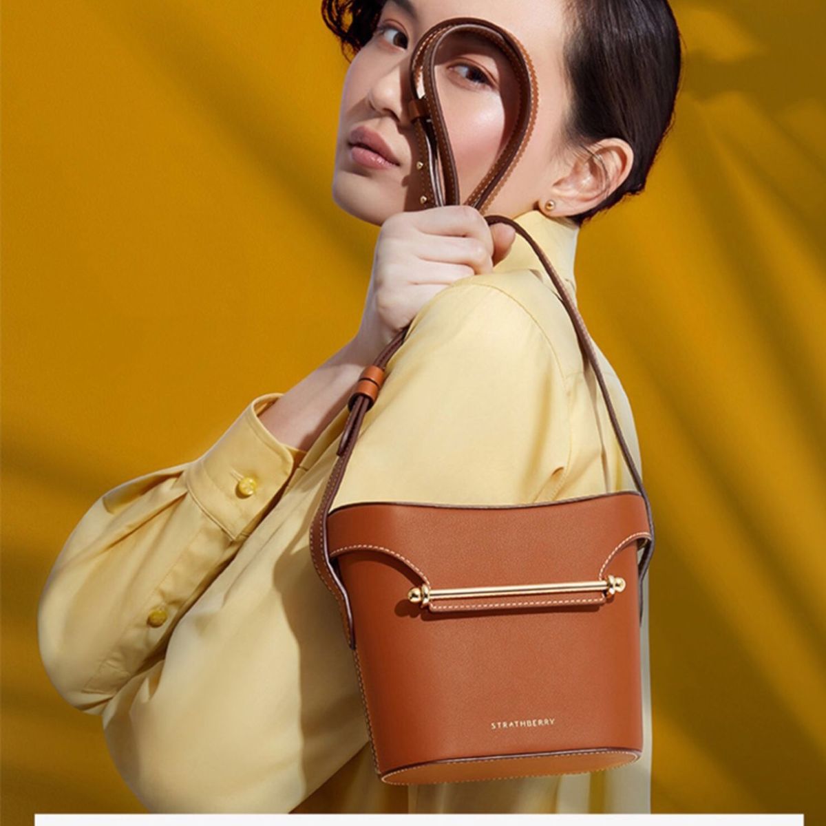 前面分享了Strathberry经典的信封包款式，金属杆设计